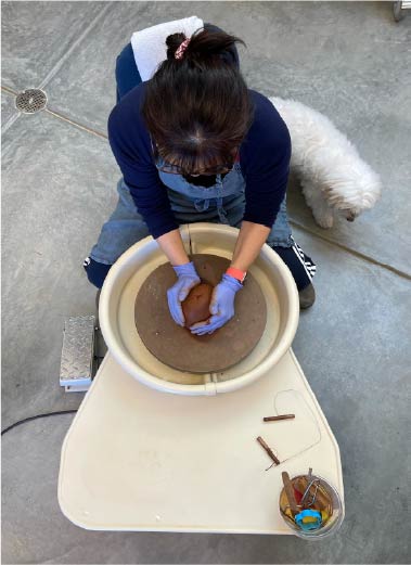 Miki Youngs spinning a pottery wheel